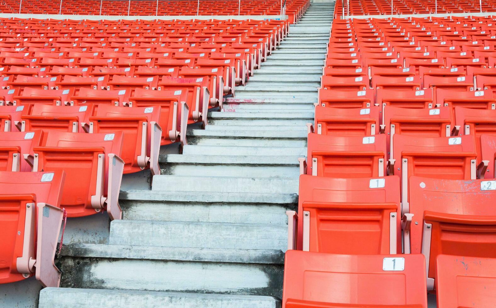 leeg oranje stoelen Bij stadion, rijen loopbrug van stoel Aan een voetbal stadion foto