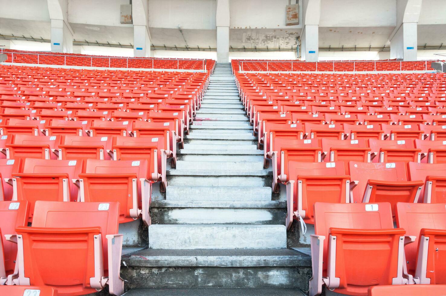 leeg oranje stoelen Bij stadion, rijen loopbrug van stoel Aan een voetbal stadion foto