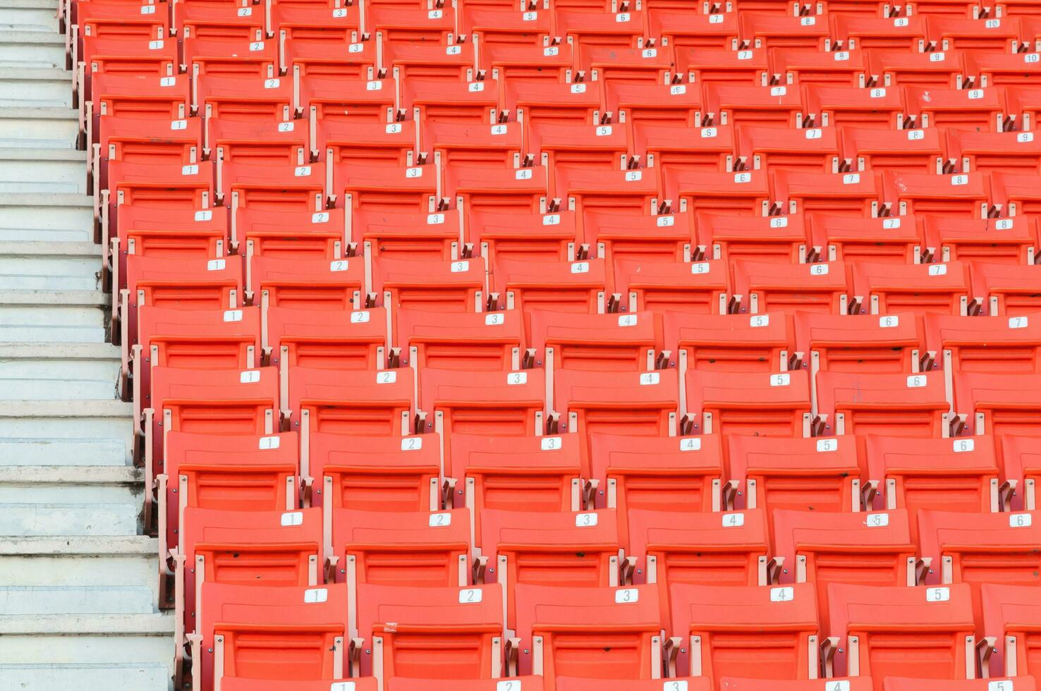 leeg oranje stoelen Bij stadion, rijen loopbrug van stoel Aan een voetbal stadion foto