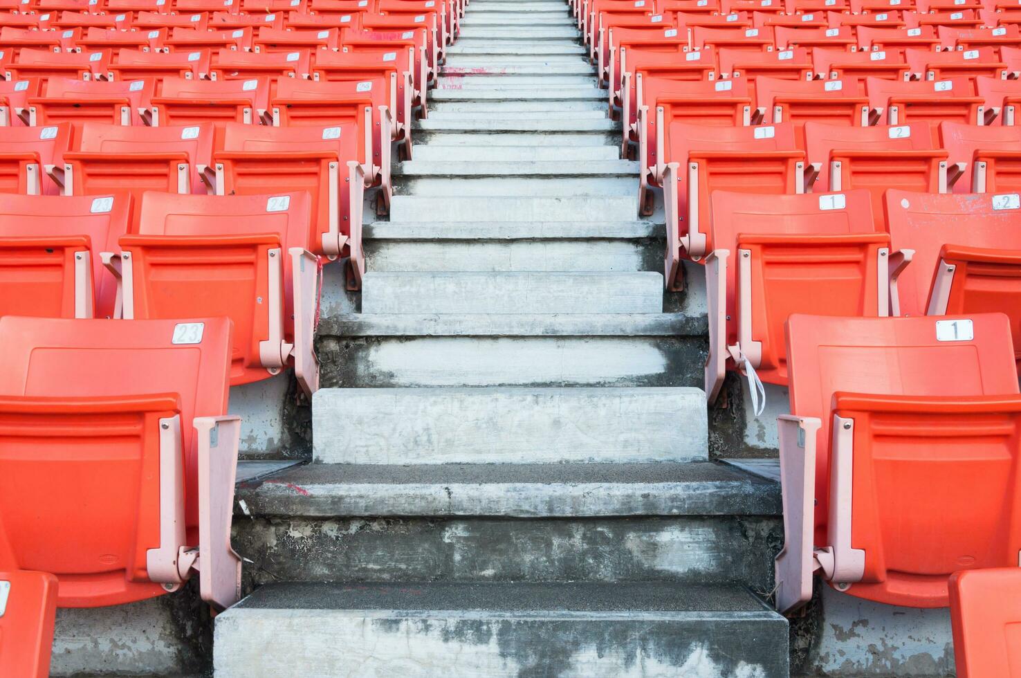 leeg oranje stoelen Bij stadion, rijen loopbrug van stoel Aan een voetbal stadion foto