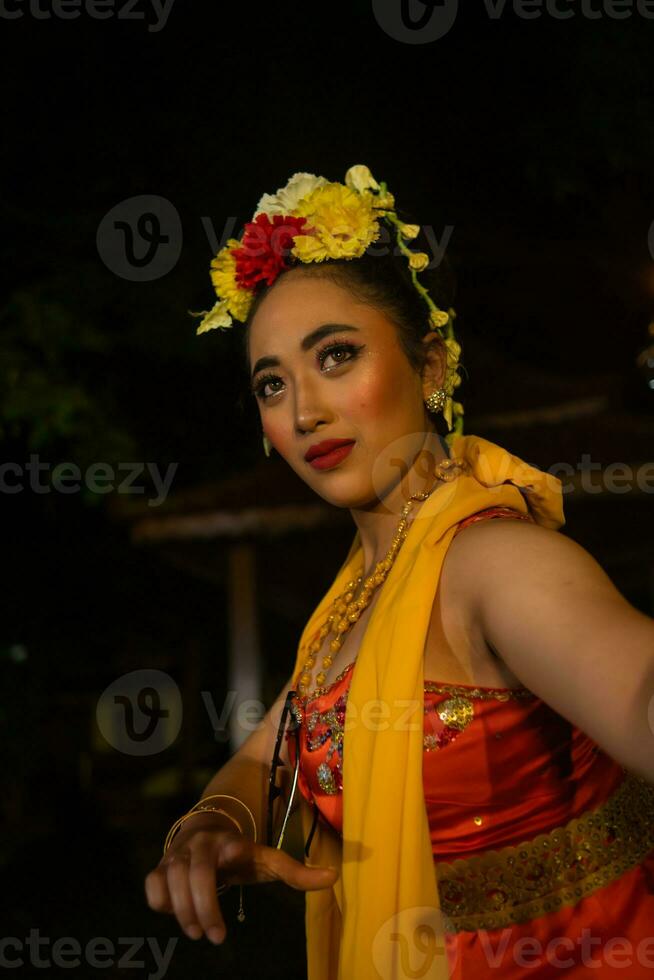 portret van een traditioneel Sundanees danser dansen met een oranje sjaal hangende naar beneden haar lichaam foto