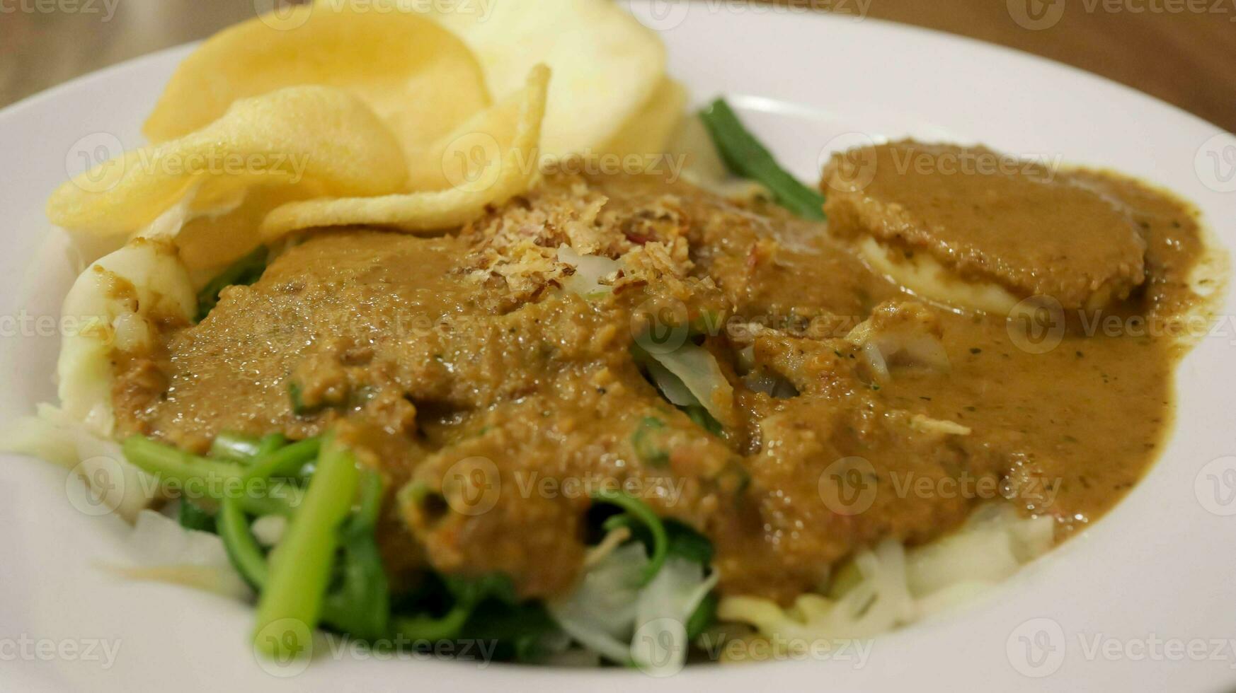 Indonesisch voedsel borst, traditioneel Javaans schotel bestaat van mengen vers groenten en pinda saus dressing, met extra kerupuk of crackers, Aan de bord. dichtbij omhoog foto