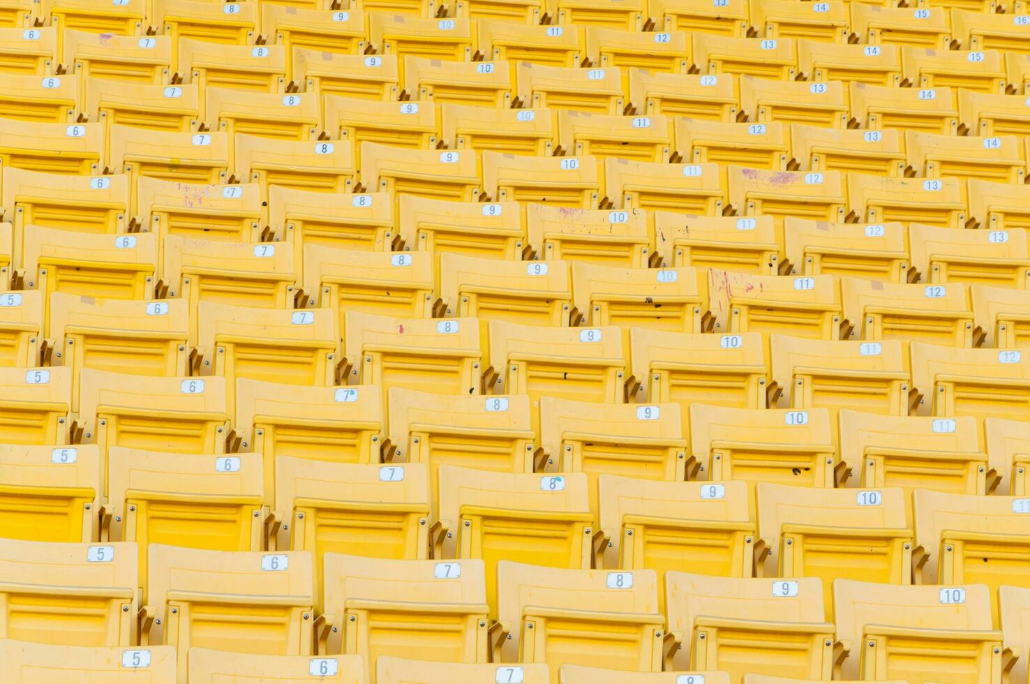 leeg geel stoelen Bij stadion, rijen van stoel Aan een voetbal stadion, selecteer focus foto