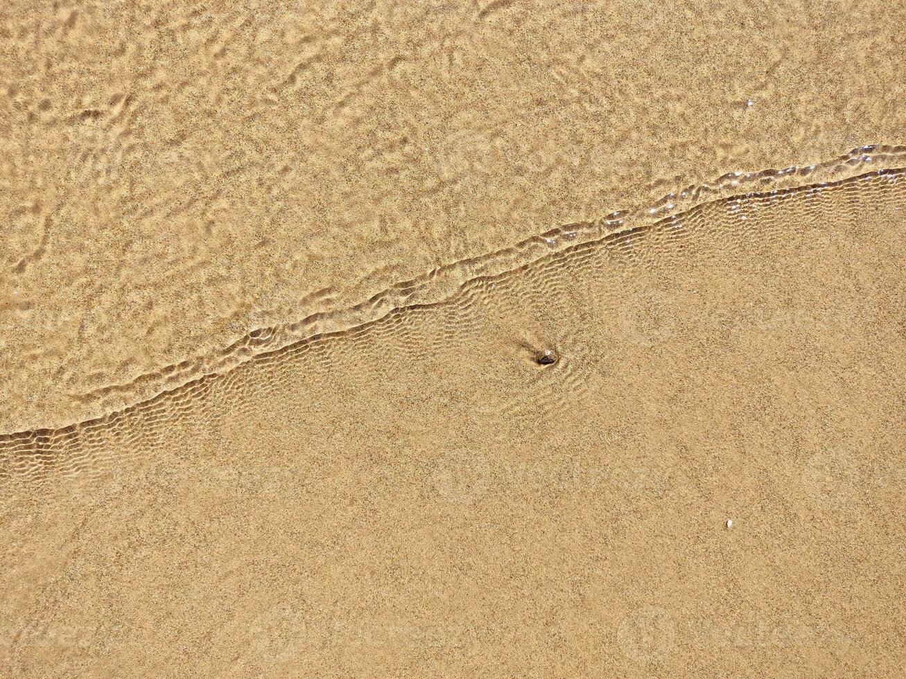 strand nat zand textuur. zanderig kust beige achtergrond. foto