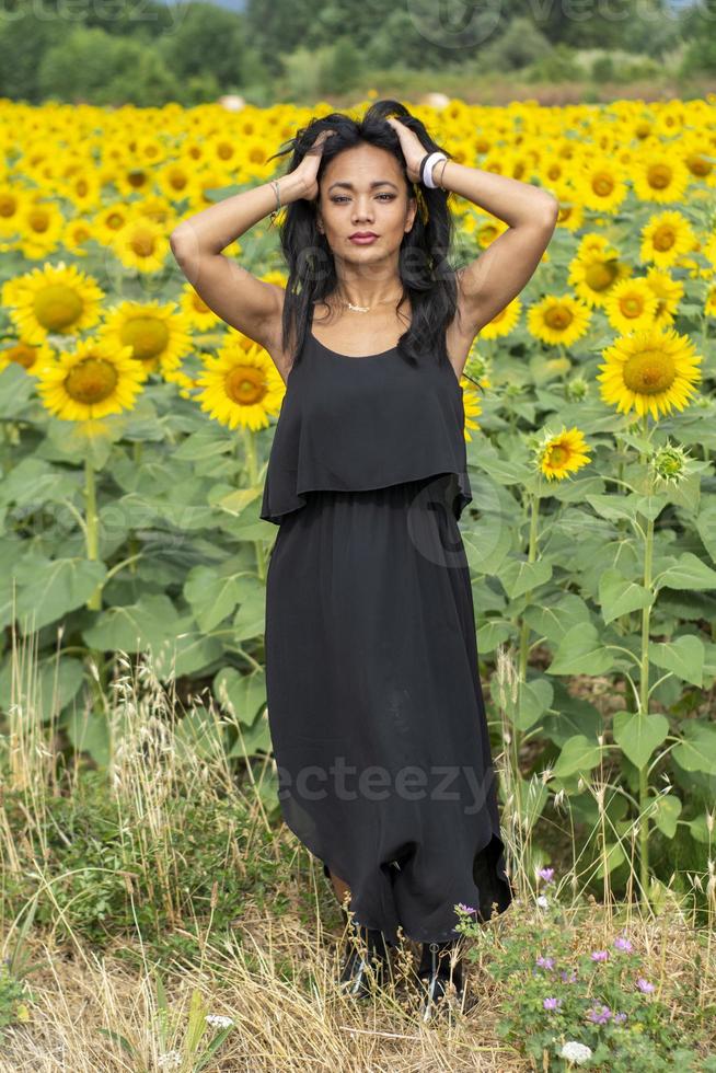 indisch meisje snuift een zonnebloembloem foto