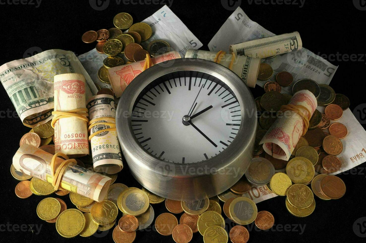 een klok is omringd door geld en munten foto