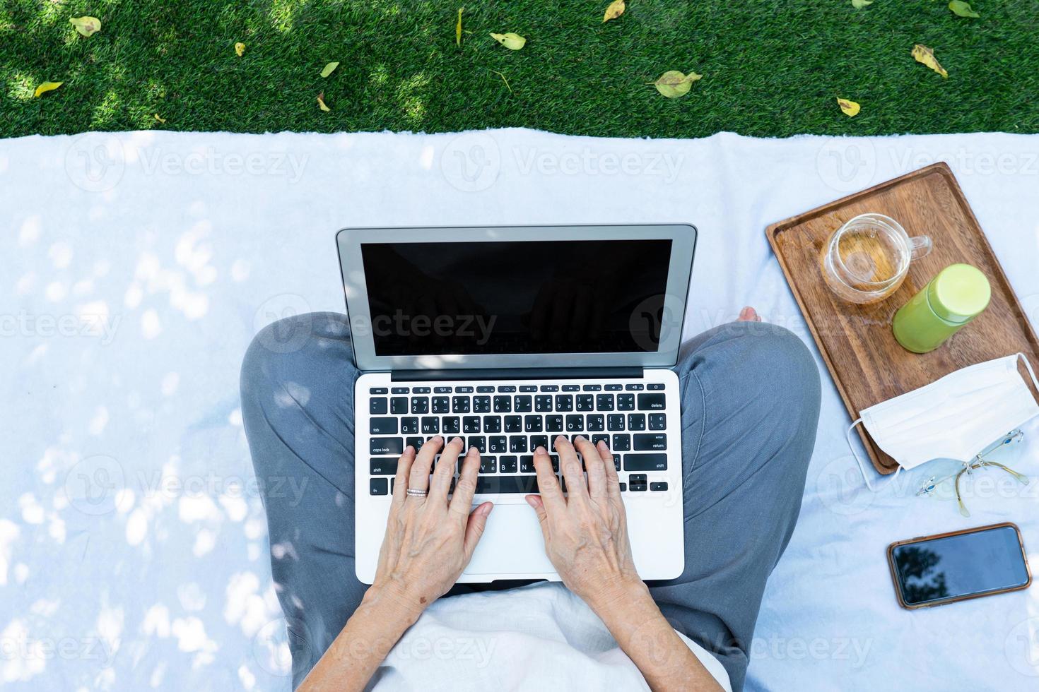 persoon die buiten op laptop werkt foto