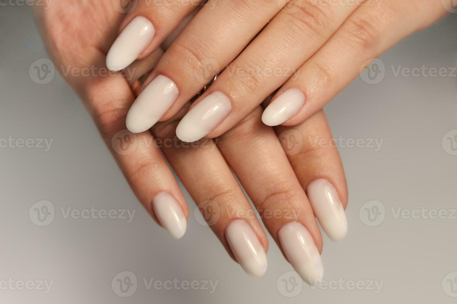 naakt manicuren. lang amandel vormig nagels. nagel ontwerp. manicure met gel Pools. detailopname van de handen van een jong vrouw met een teder naakt manicure Aan haar nagels. helder nagels met gel Pools. foto