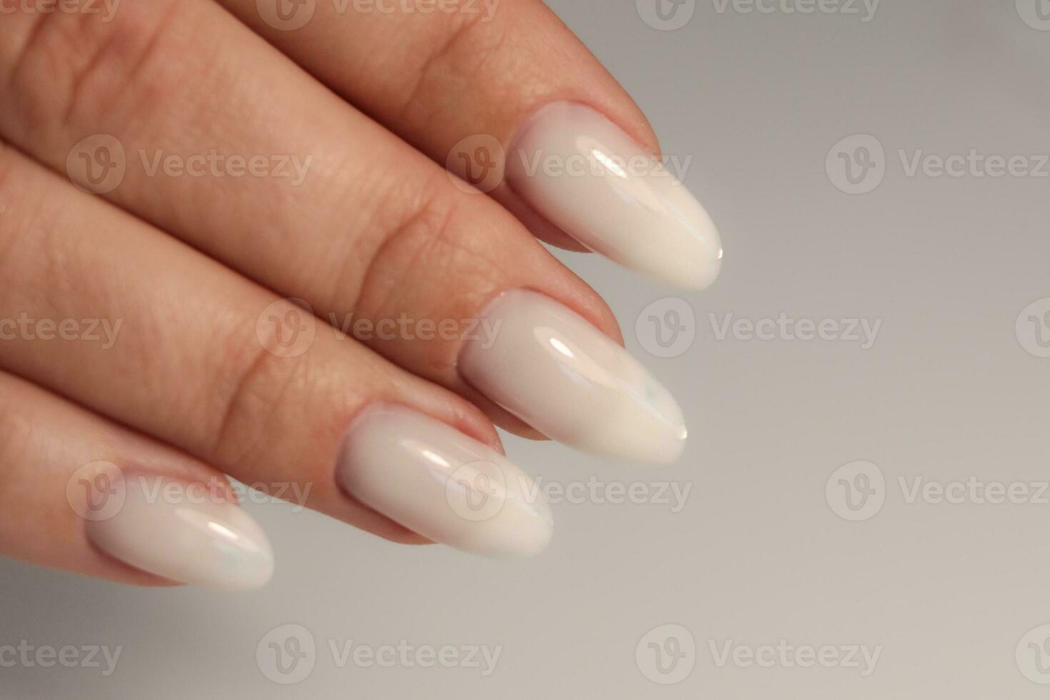 naakt manicuren. lang amandel vormig nagels. nagel ontwerp. manicure met gel Pools. detailopname van de handen van een jong vrouw met een teder naakt manicure Aan haar nagels. helder nagels met gel Pools. foto