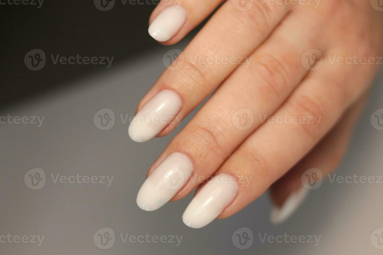 naakt manicuren. lang amandel vormig nagels. nagel ontwerp. manicure met gel Pools. detailopname van de handen van een jong vrouw met een teder naakt manicure Aan haar nagels. helder nagels met gel Pools. foto