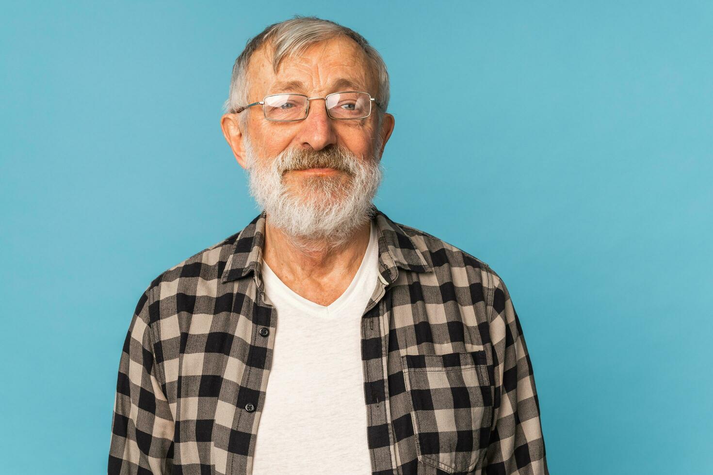 detailopname portret van een senior Mens denken over iets Aan blauw achtergrond foto