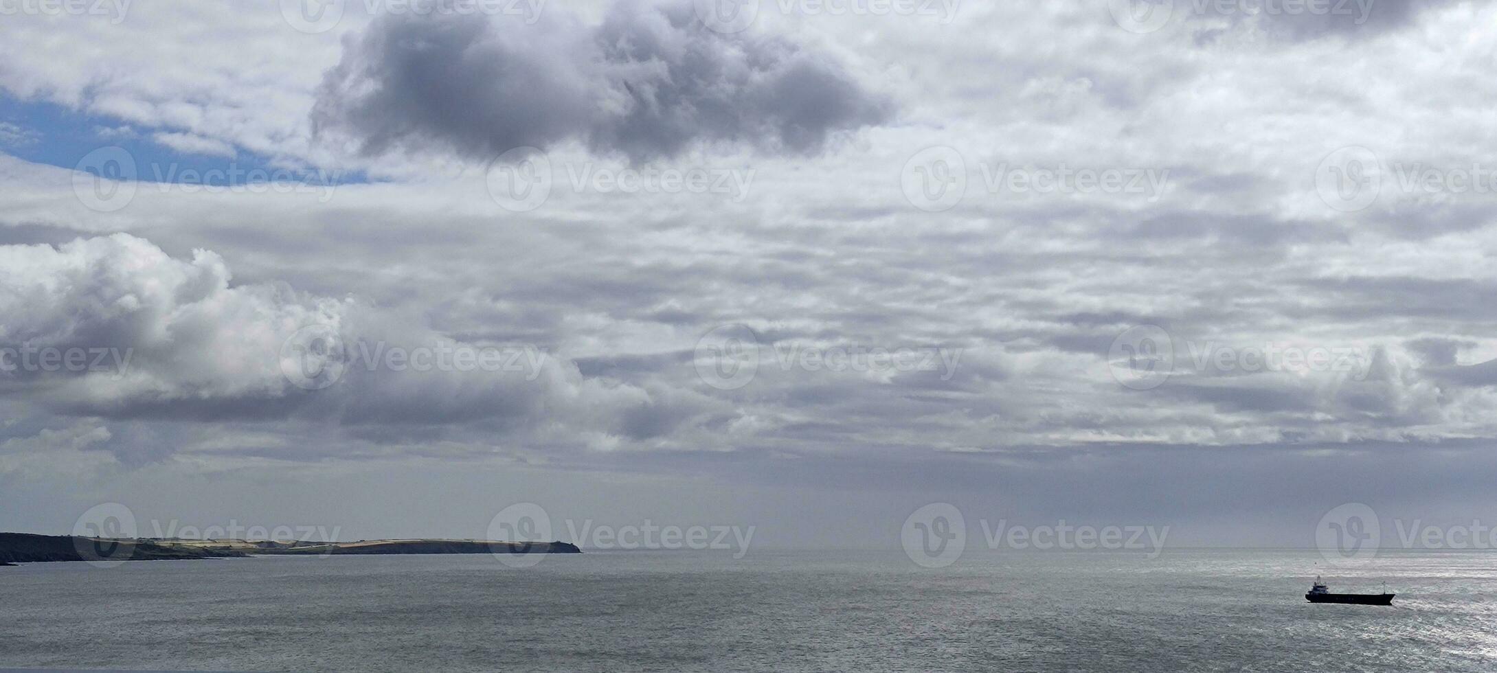 lading schip in de Open stormachtig zee. met zwaar regenachtig lucht achtergrond foto