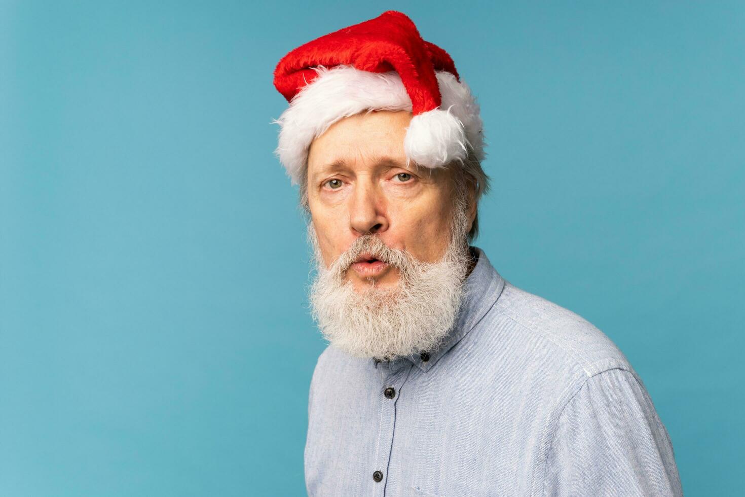 portret van verrast de kerstman claus Aan blauw achtergrond - emoties en winter vakantie concept foto