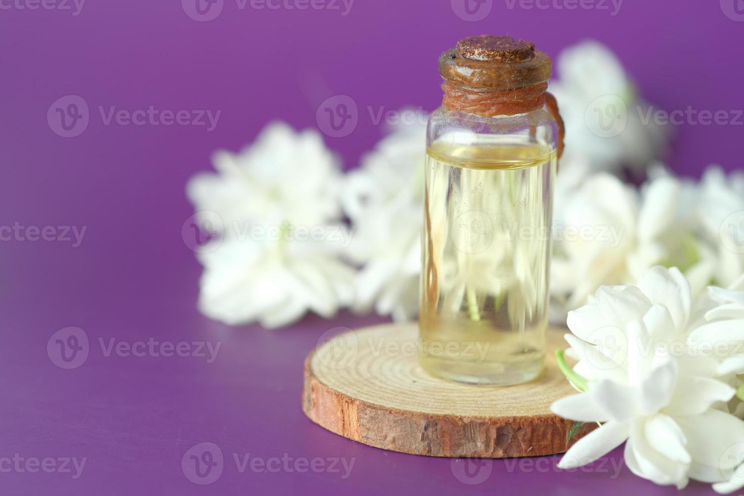 Eucalyptus etherische oliën in een glazen fles en bloem op paarse achtergrond foto