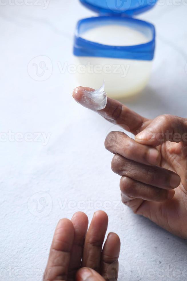 senior vrouw die vaseline op de huid gebruikt foto