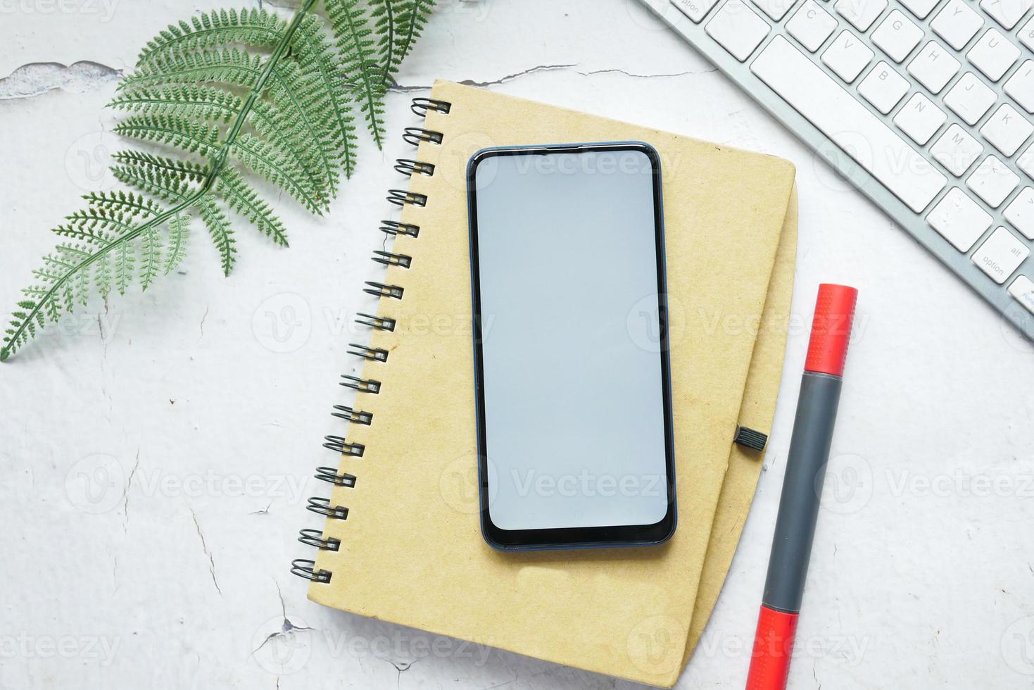 slimme telefoon met leeg scherm op notitieblok op tafel foto