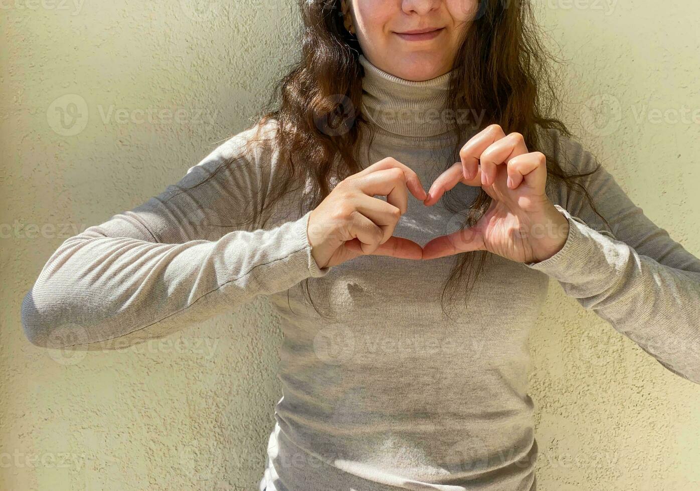 een vrouw shows een hart met haar handen. foto