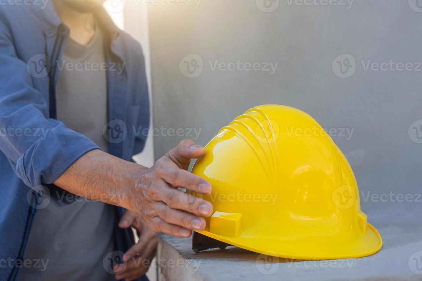 ingenieur die veiligheidshelm op bouwplaats houdt foto