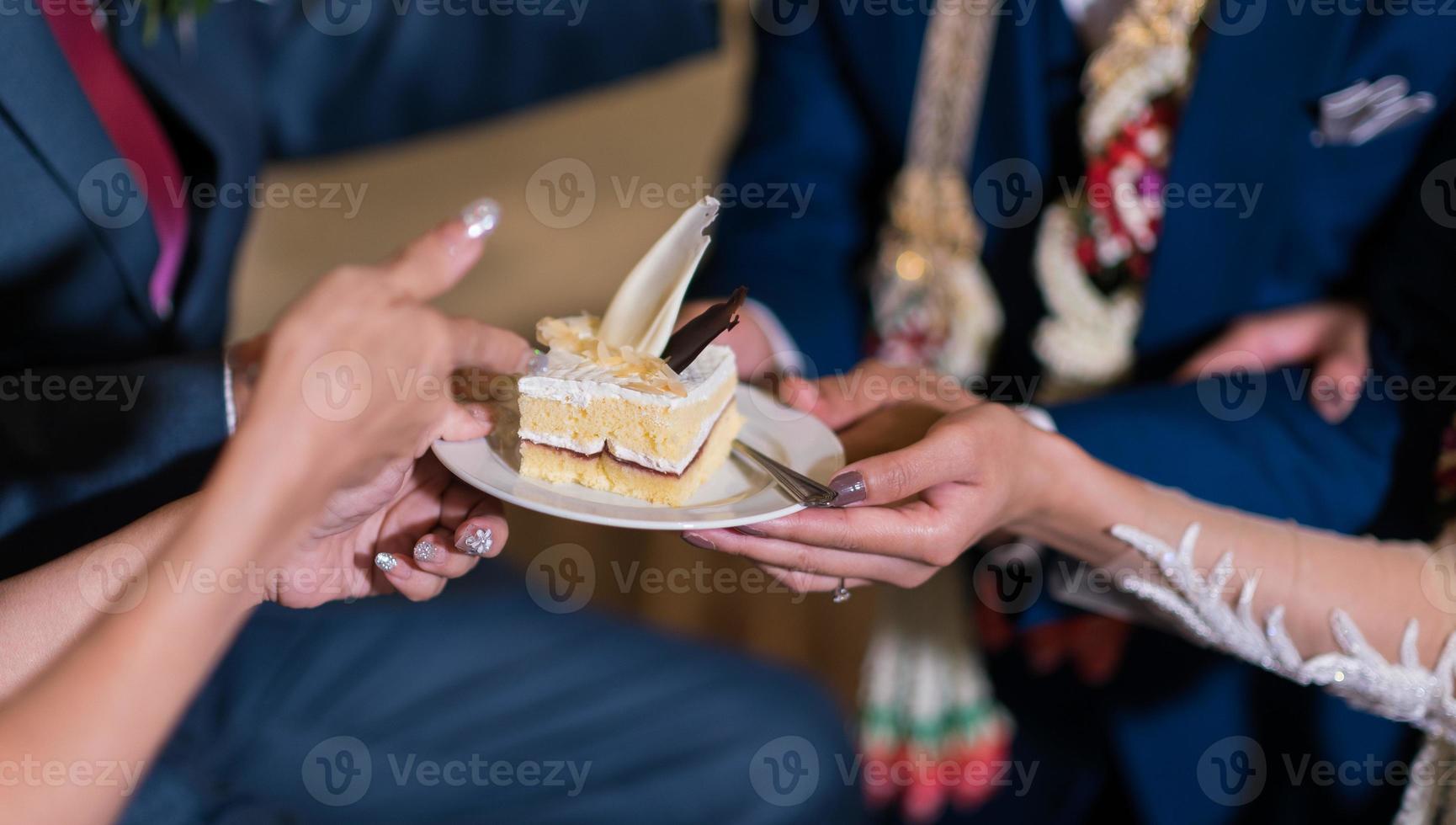 de bruid en bruidegom geven de taart foto