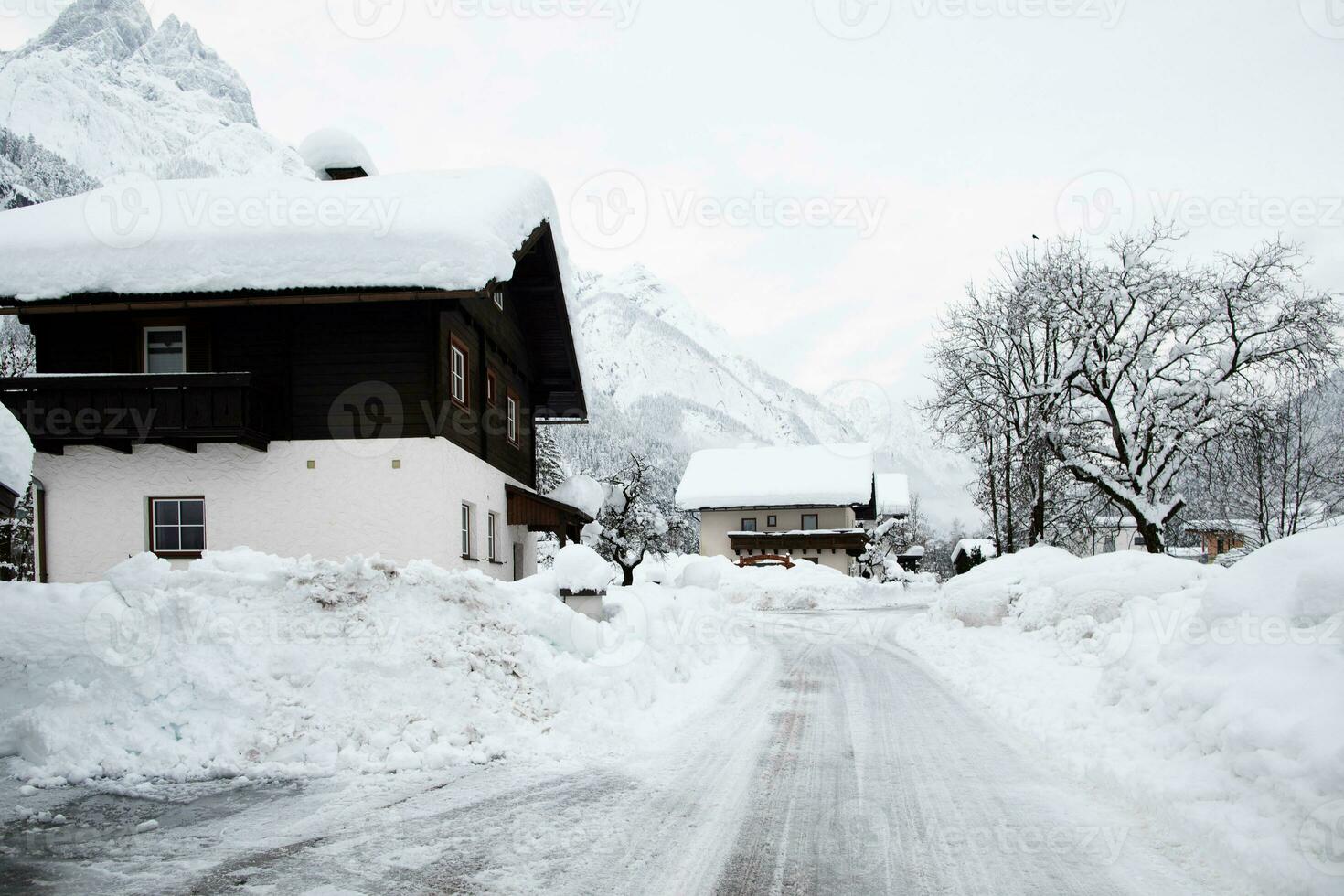 een besneeuwd weg in voorkant van een huis foto