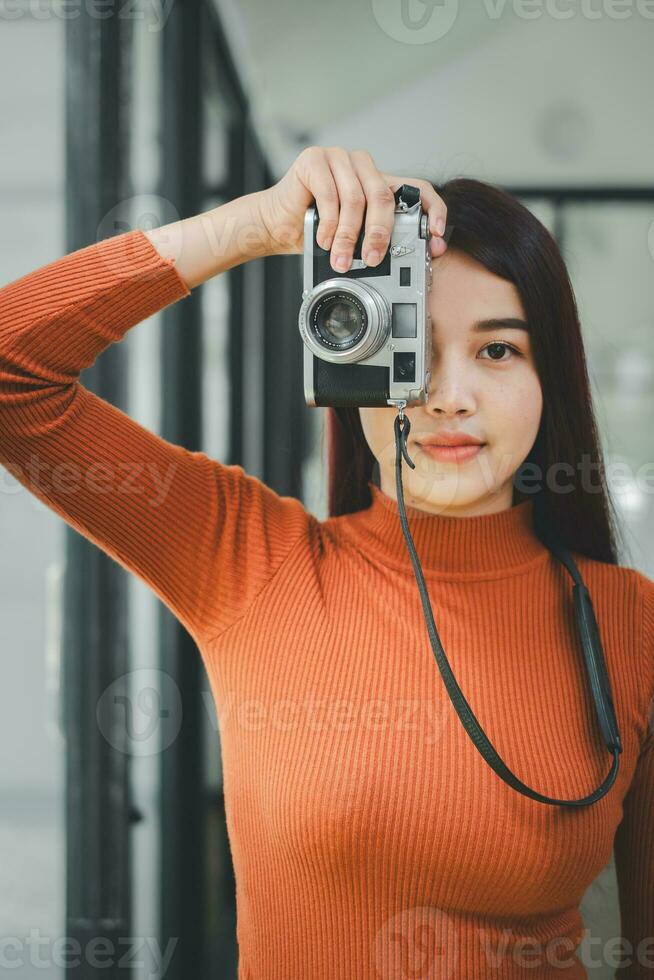 hipster vrouw nemen foto's met retro film camera Aan de veld. foto