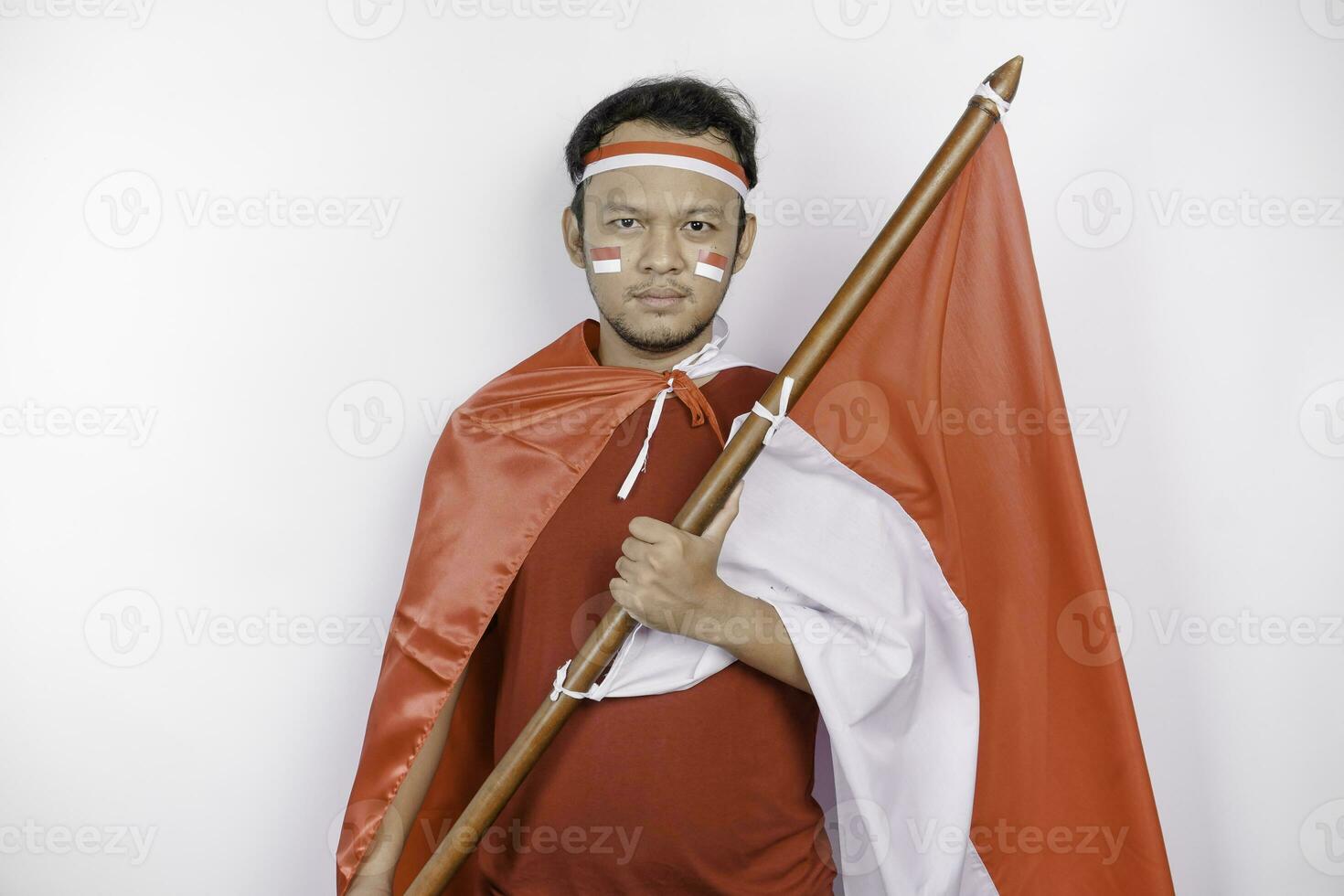 gelukkig glimlachen Indonesisch Mens Holding Indonesië's vlag naar vieren Indonesië onafhankelijkheid dag geïsoleerd over- wit achtergrond. foto