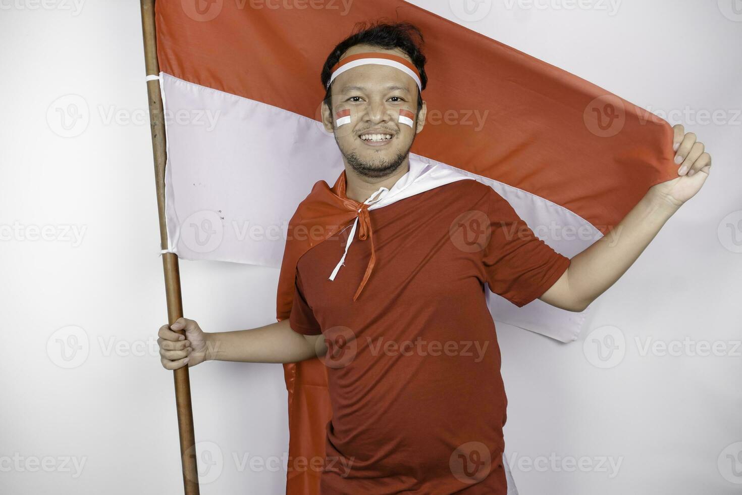 gelukkig glimlachen Indonesisch Mens Holding Indonesië's vlag naar vieren Indonesië onafhankelijkheid dag geïsoleerd over- wit achtergrond. foto