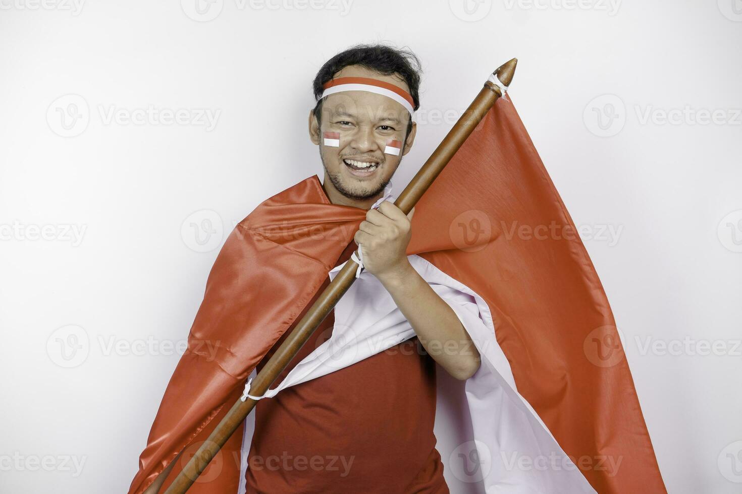 gelukkig glimlachen Indonesisch Mens Holding Indonesië's vlag naar vieren Indonesië onafhankelijkheid dag geïsoleerd over- wit achtergrond. foto