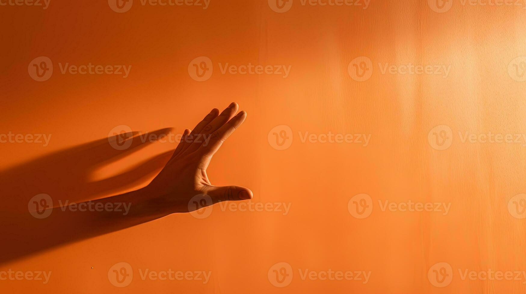 elegant vorm van een hand- schaduw Aan een oranje lit muur in kleur. silhouet concept foto