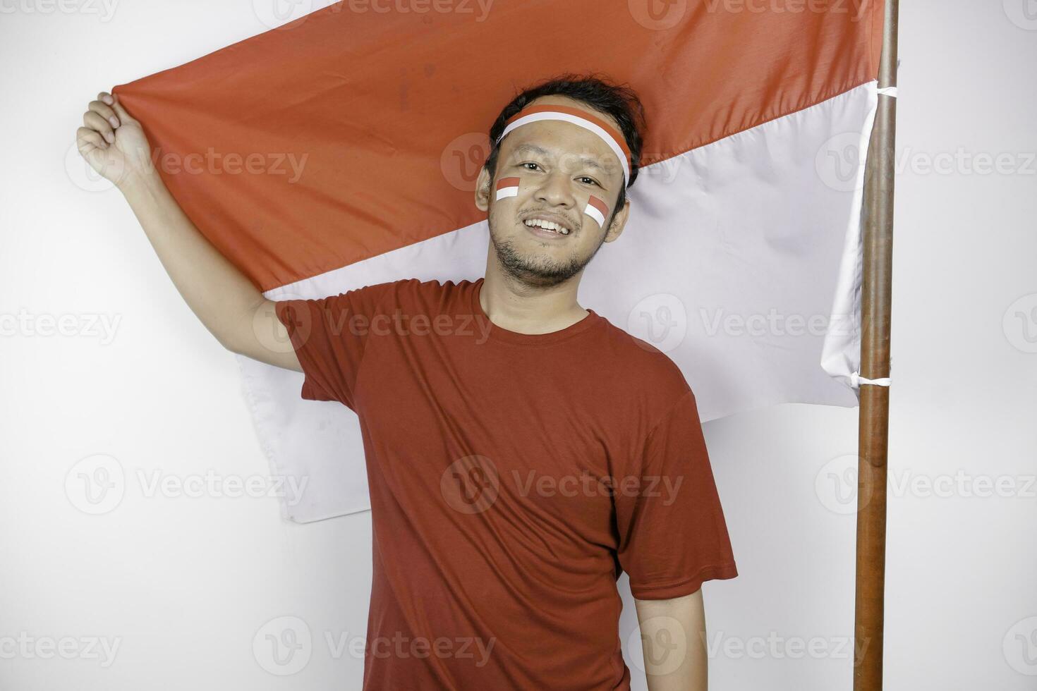 gelukkig glimlachen Indonesisch Mens Holding Indonesië's vlag naar vieren Indonesië onafhankelijkheid dag geïsoleerd over- wit achtergrond. foto