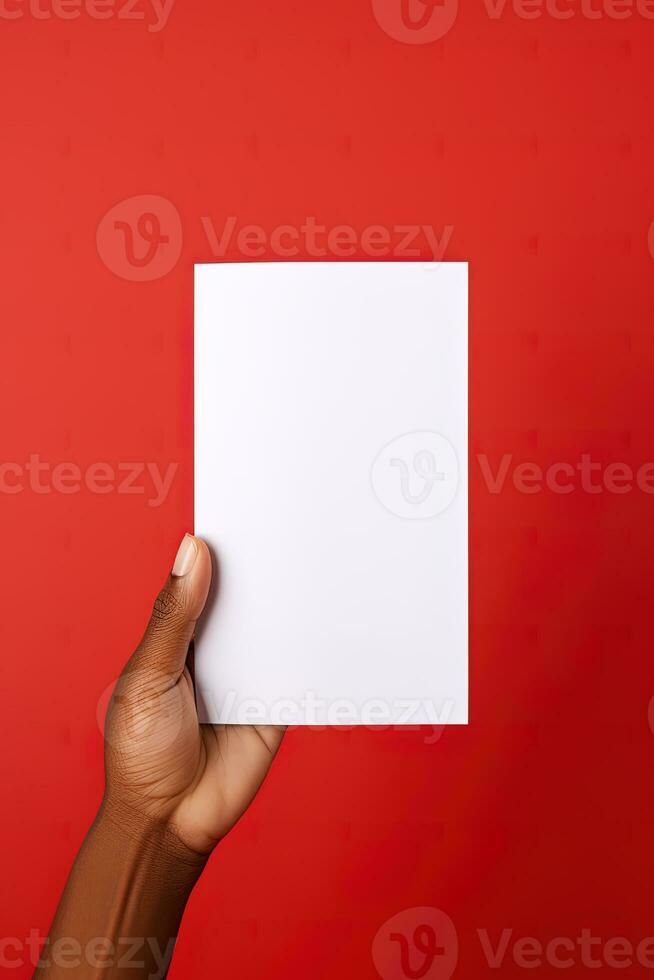 een menselijk hand- Holding een blanco vel van wit papier of kaart geïsoleerd Aan rood achtergrond. ai gegenereerd foto