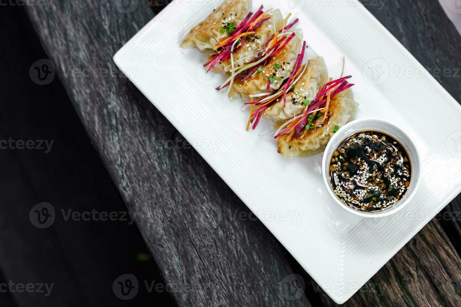 een bord van gyoza Aan een tafel foto