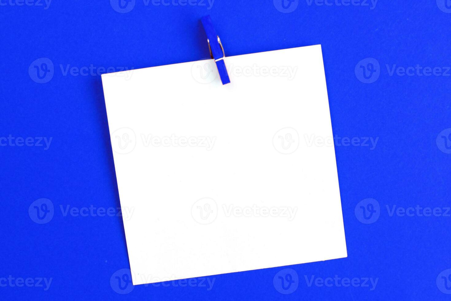 sticker met leeg mockup voor uw tekst hangende Aan de pin Aan blauw achtergrond. kopiëren ruimte voor tekst foto