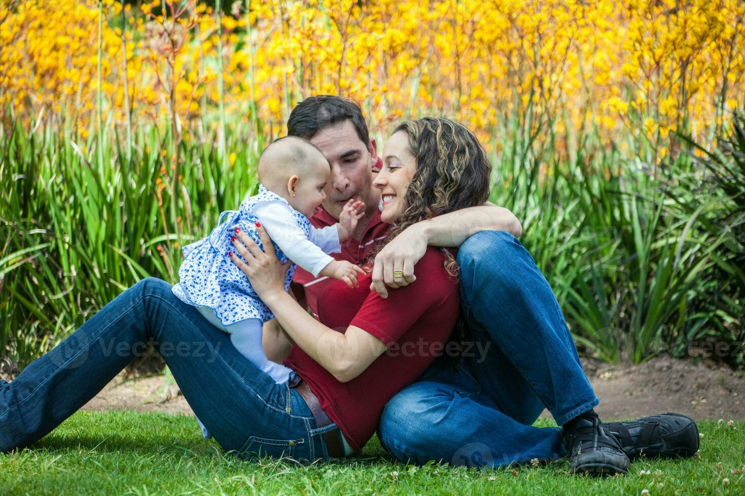 jong ouders hebben pret buitenshuis met hun zes maanden oud baby meisje. geluk concept. familie concept foto