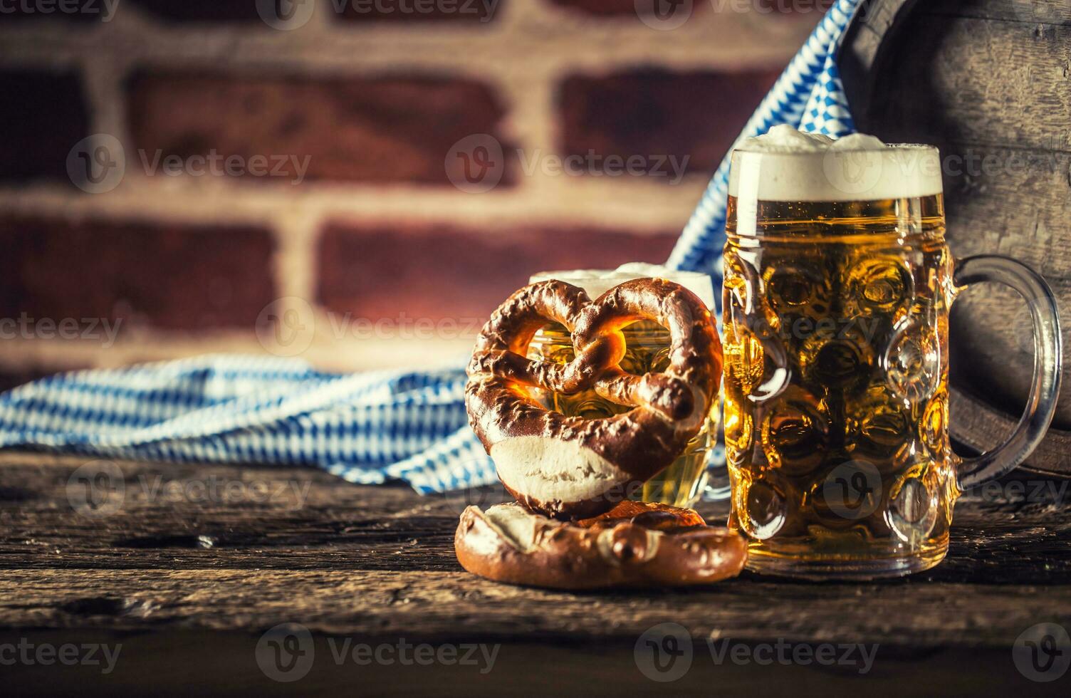 oktoberfeest groot en klein bier met zoute krakeling houten vat en blauw tafelkleed foto