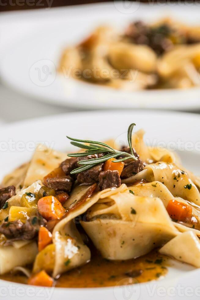 idaliaans pasta pappardelle met rundvlees ragoût Aan wit bord. foto