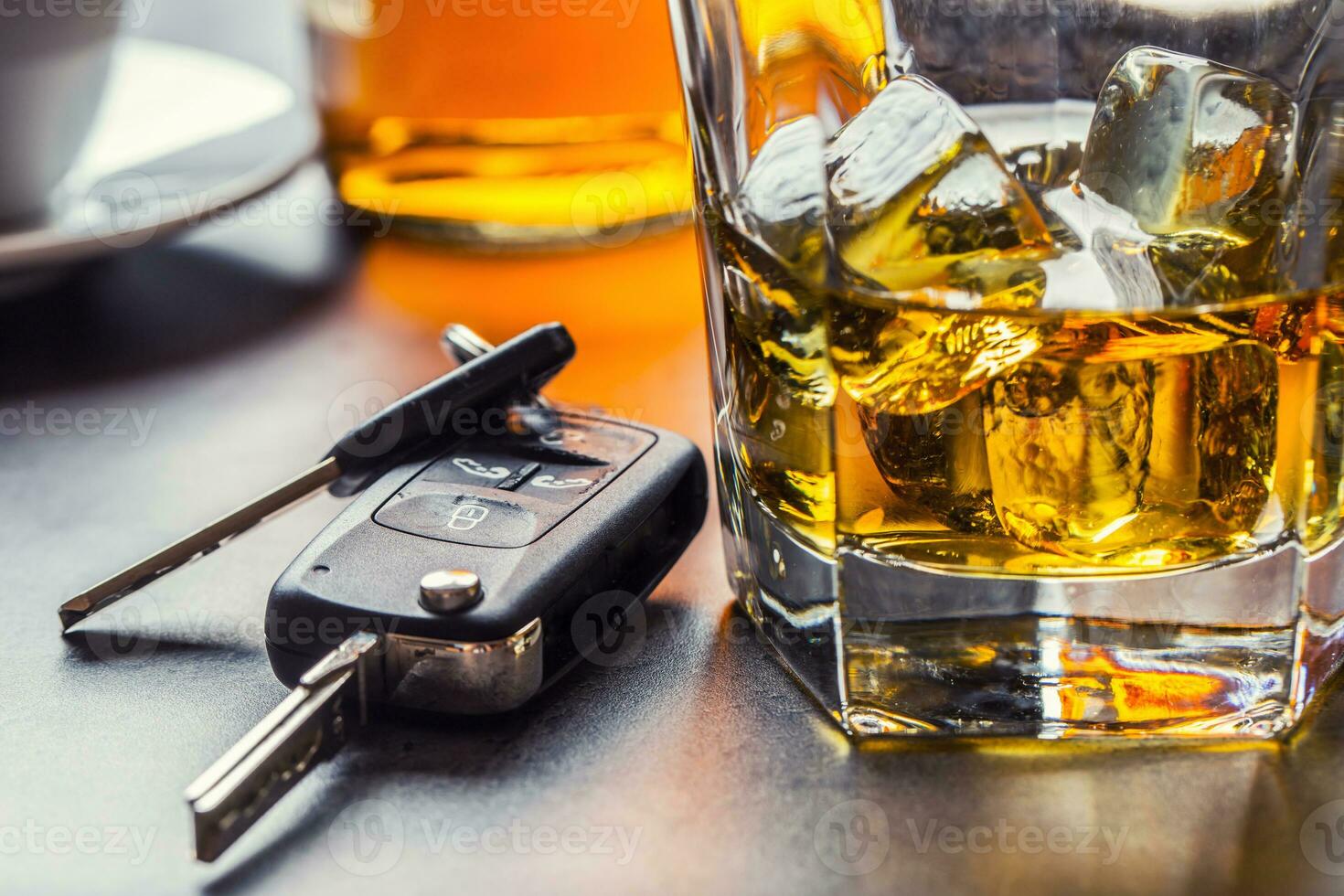 auto sleutels en glas van alcohol Aan tafel. foto