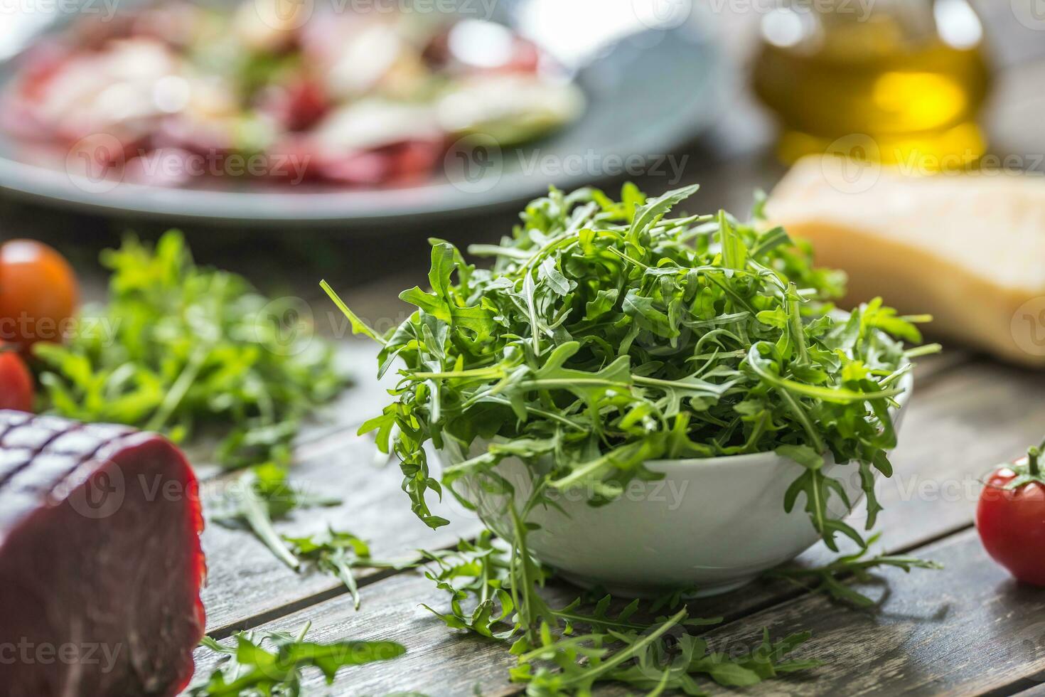 vers rucola salade in wit schotel Aan houten tafel foto