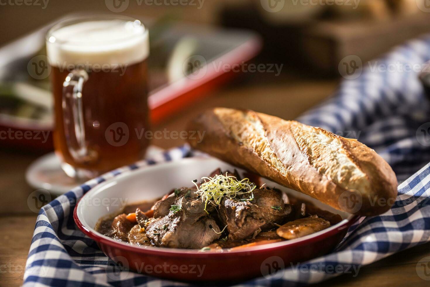 gebraden wild zwijn met wortel paddestoelen, baguette en droogte bier foto