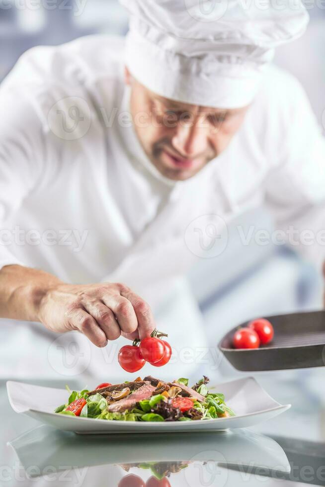 chef in de keuken van de hotel of restaurant siert de voedsel alleen maar voordat portie foto