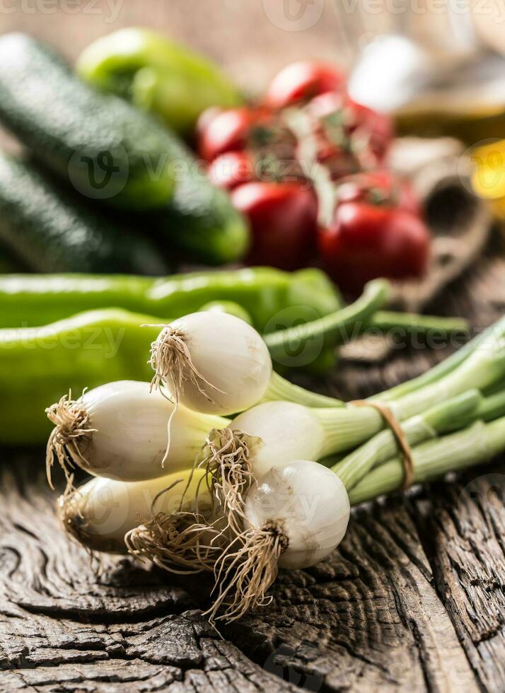 vers groente ui komkommer peper en tomaten Aan rustiek eik tafel foto