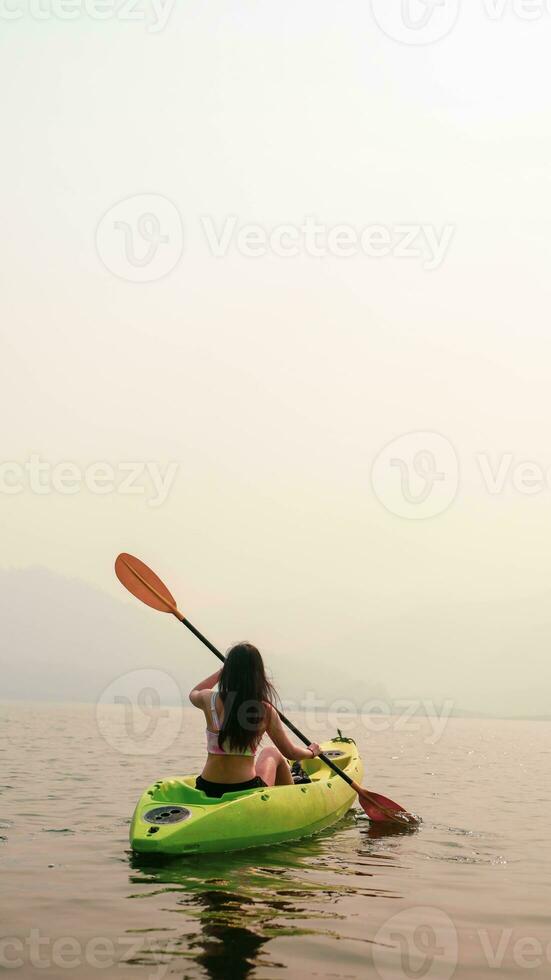 kajak water sport- Bij meer. kajakkers genieten van de mooi zonsopkomst wandelingen door zee kajak of kano Bij tropisch baai. ontspannende met boot strand zomer vakantie foto