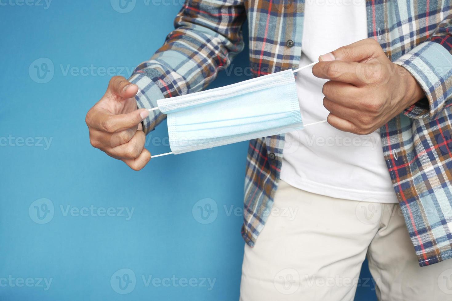 man's hand met chirurgisch gezichtsmasker, close-up foto