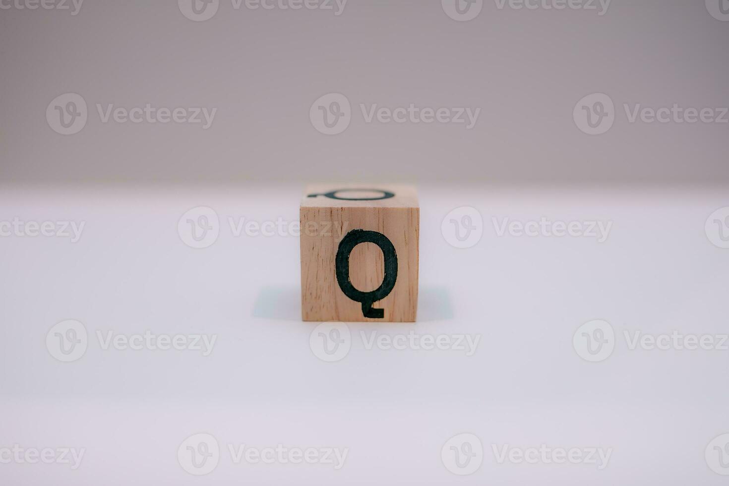 houten blok geschreven q met een wit achtergrond, onderwijs concept, dichtbij omhoog. foto