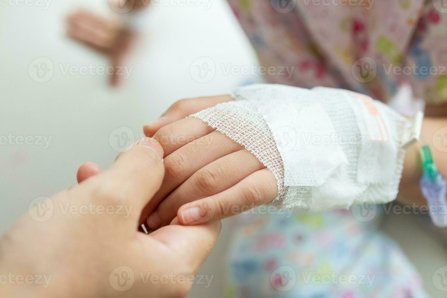 moeder Holding kind hand- met zoutoplossing iv oplossing in ziekenhuis foto