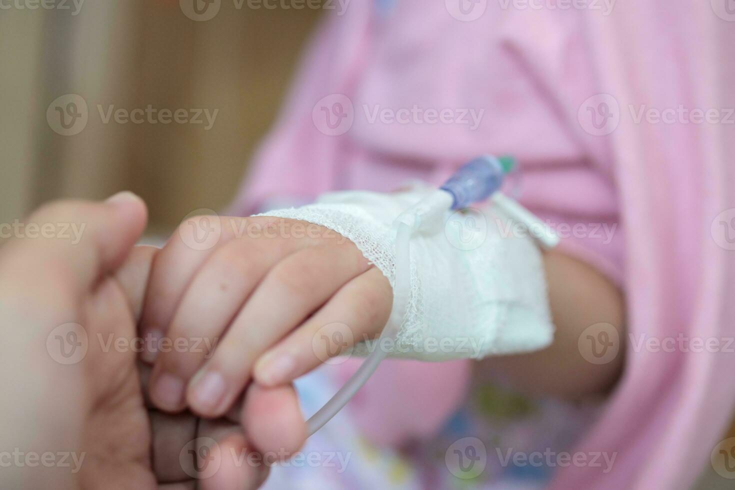 moeder Holding kind hand- met zoutoplossing iv oplossing in ziekenhuis foto