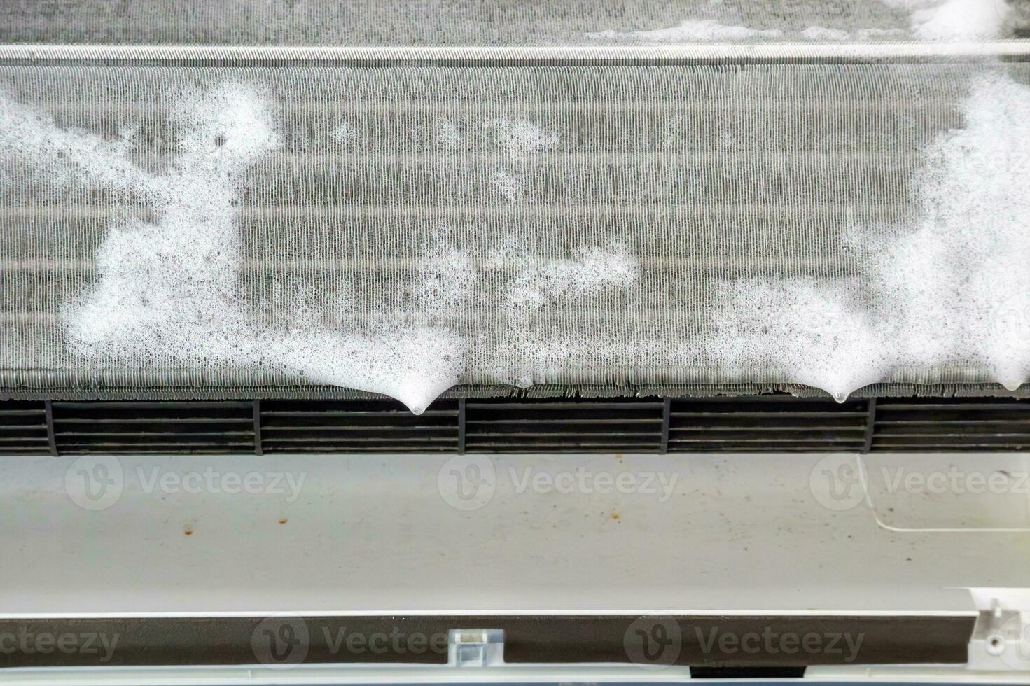 lucht conditioner schoonmaak met verstuiven schuim schoonmaakster foto