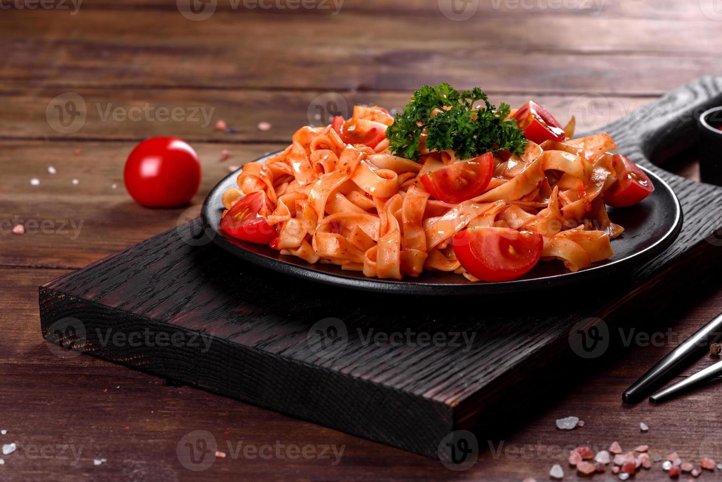 heerlijke verse pasta met tomatensaus met specerijen en kruiden op een donkere achtergrond foto