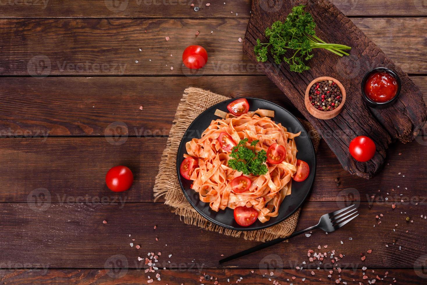 heerlijke verse pasta met tomatensaus met specerijen en kruiden op een donkere achtergrond foto