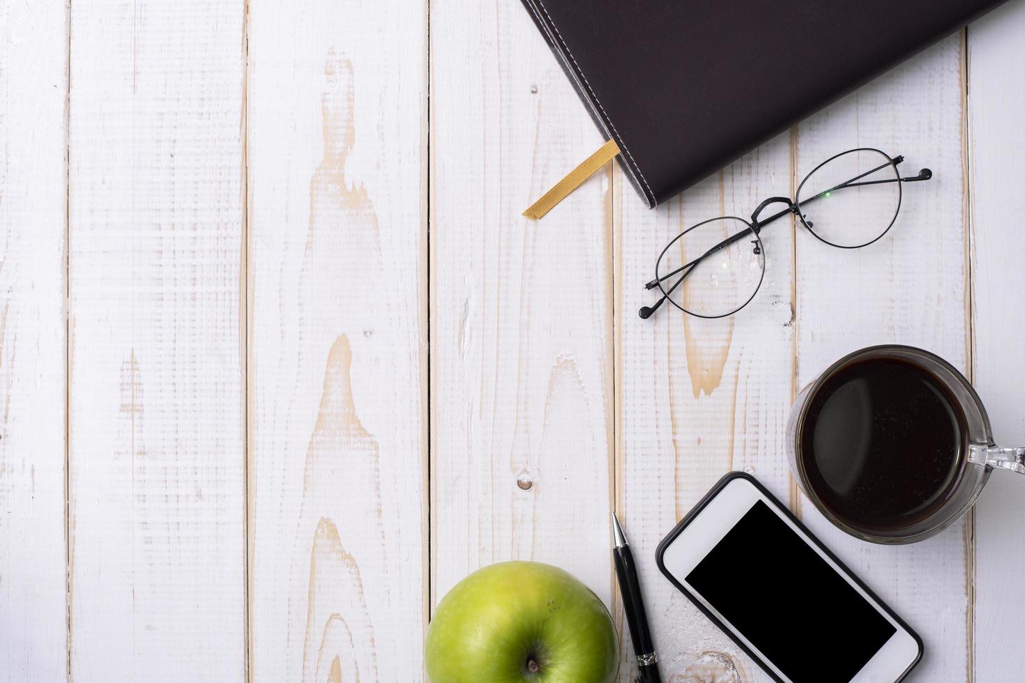 werkruimte bovenaanzicht achtergrond, kantooraccessoire op witte houten tafel foto